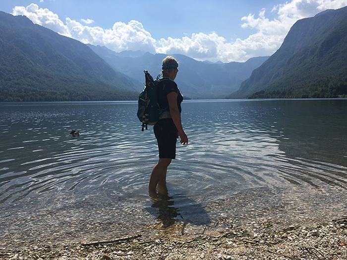 hiker standing in lake Bohinj, Slovenia