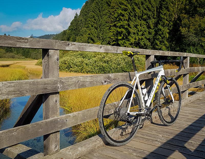 Gravel bike resting on a wooden bridge in Slovenia’s forests, part of self-guided cycling tours.