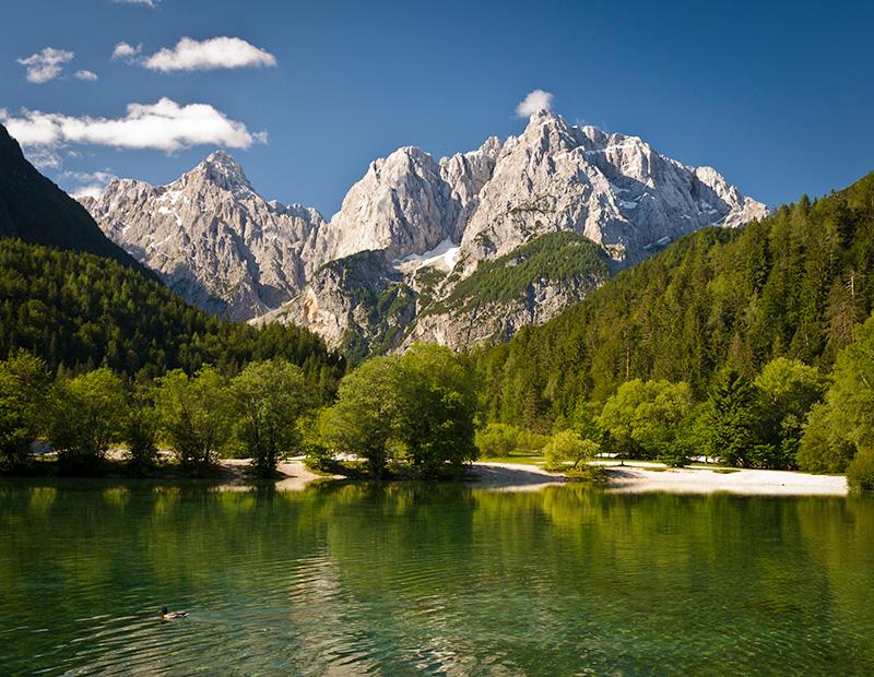 Lake Jasna near Kranjska Gora in Slovenia with alpine mountain backdrop, highlight of self-guided cycling holidays.