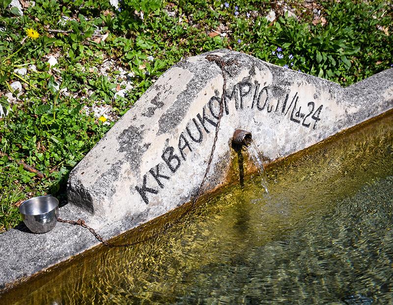 Mountain spring fountain in Slovenia with fresh alpine water, traditional stop along self-guided hiking routes in the Julian Alps.