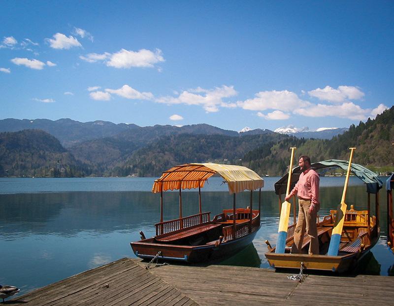 Lake Bled walking tour on a Slovenia walking holiday, boat on the glacial lake with Julian Alps in the background