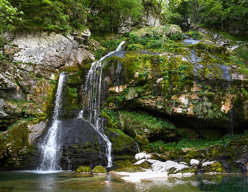 Virje Waterfall surrounded by moss-covered rocks near Bovec, Slovenia