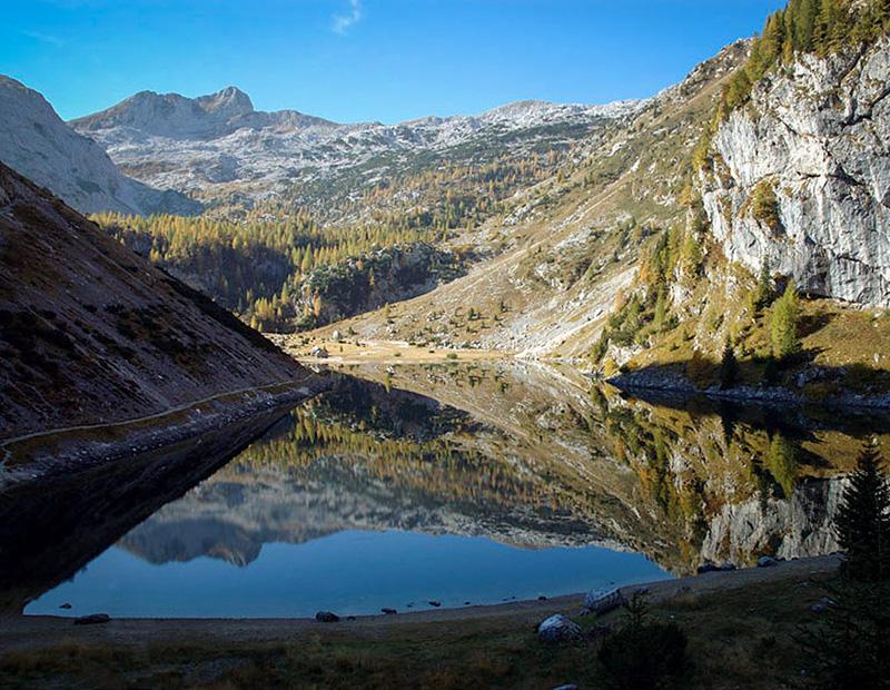 Triglav Lakes Valley in Slovenia with calm alpine lake reflections, highlight of self-guided trekking tours in the Julian Alps.